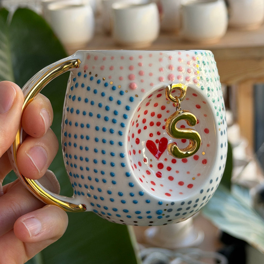 Gerçek altın harf detayıyla beyaz zemin üzerinde zarif kontrast