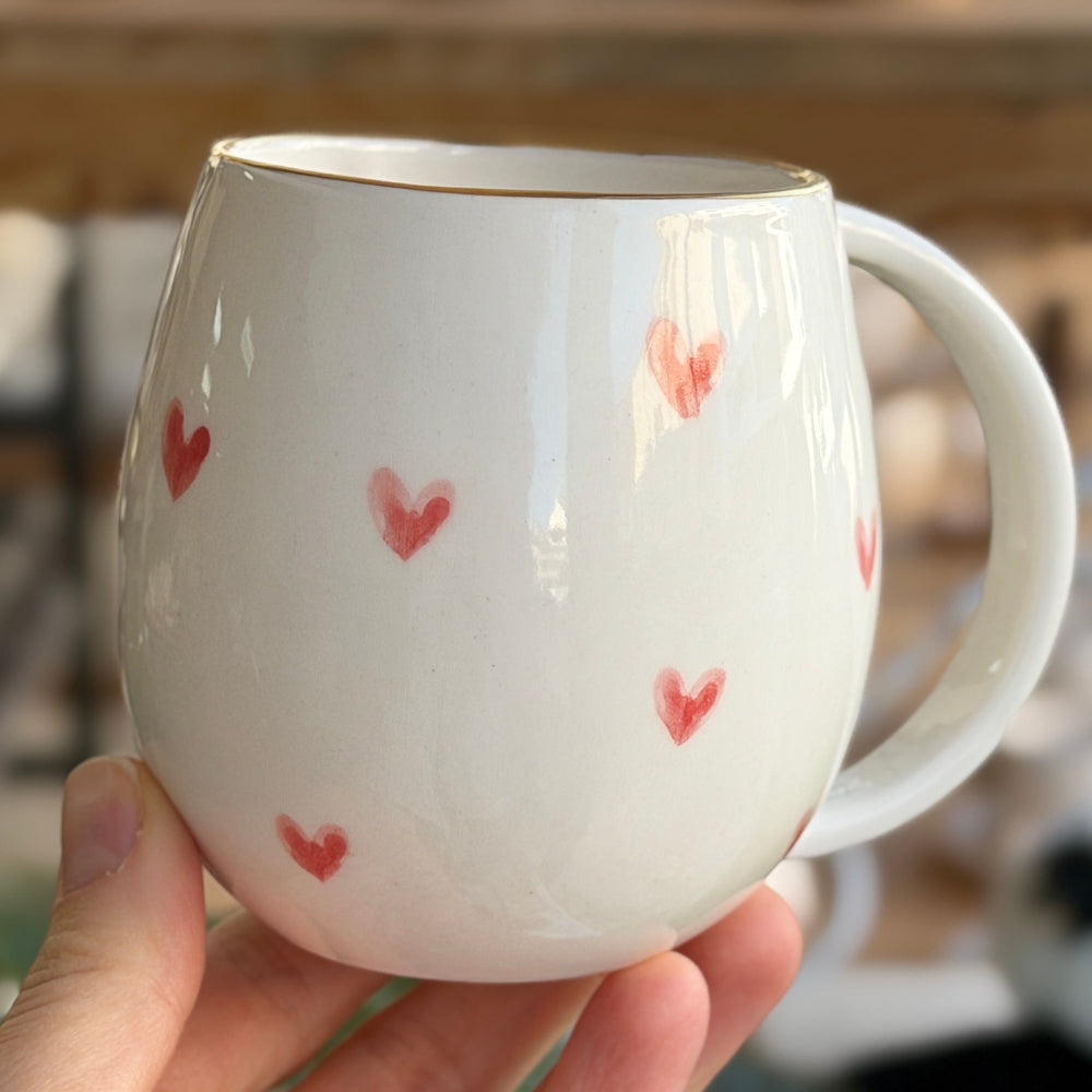 Beyaz porselen harfli kupa arka görünüm, altın harf detayı ve el çizimi figür tasarımı